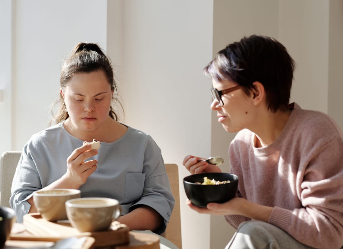Two women sharing breakfast at a sunlit table
