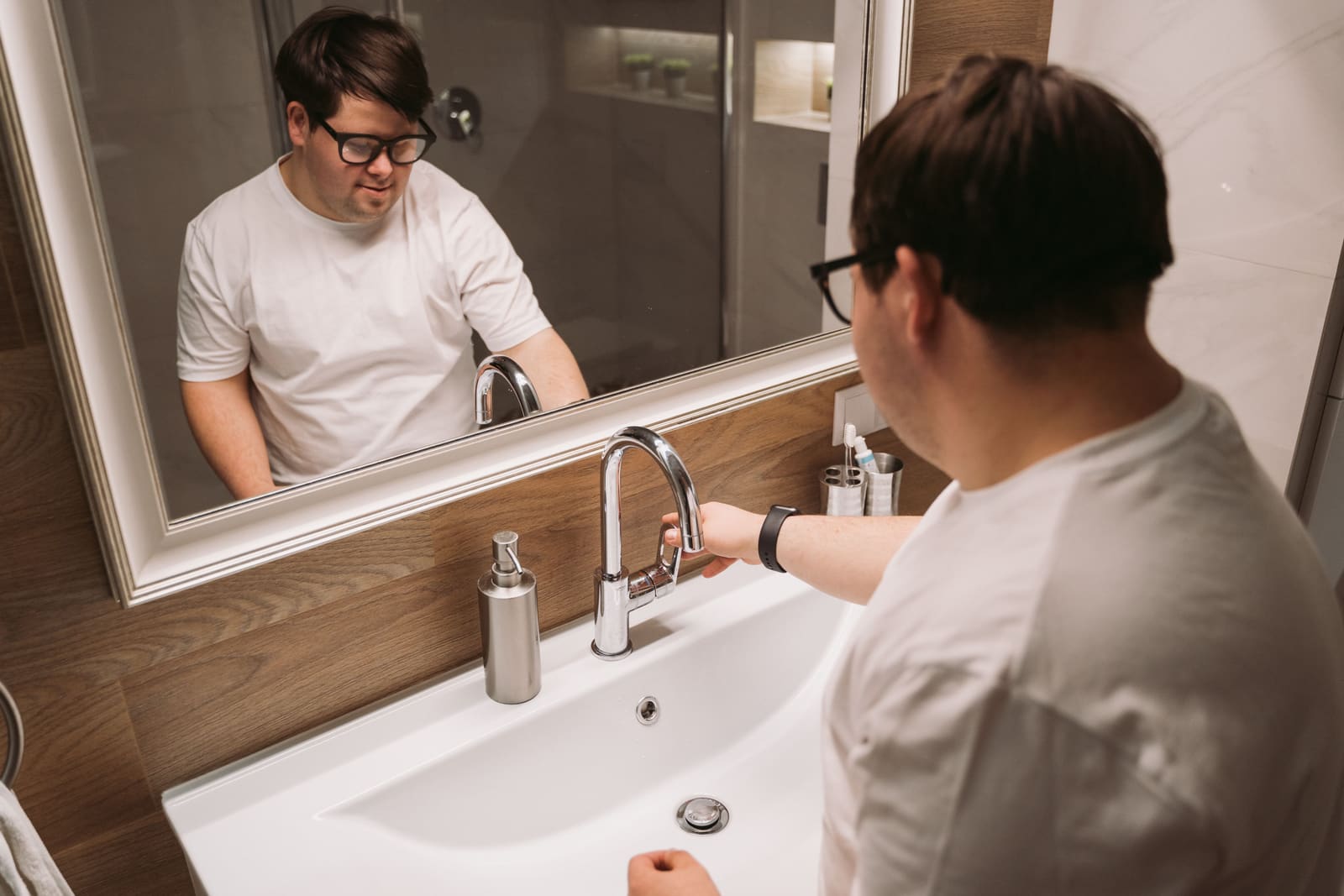 A man using the basin in an accessible bathroom
